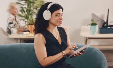 Vrouw met een Sonos Ace op haar hoofd. Ze zit op een bank