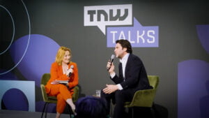 Xander de Buisonjé: ‘Markt voor hoogwaardige in-ear apparaten nog onontgonnen’ Xander de Buisonjé geinterviewd op The Next Web. Hij zit op een podium met een interviewster.