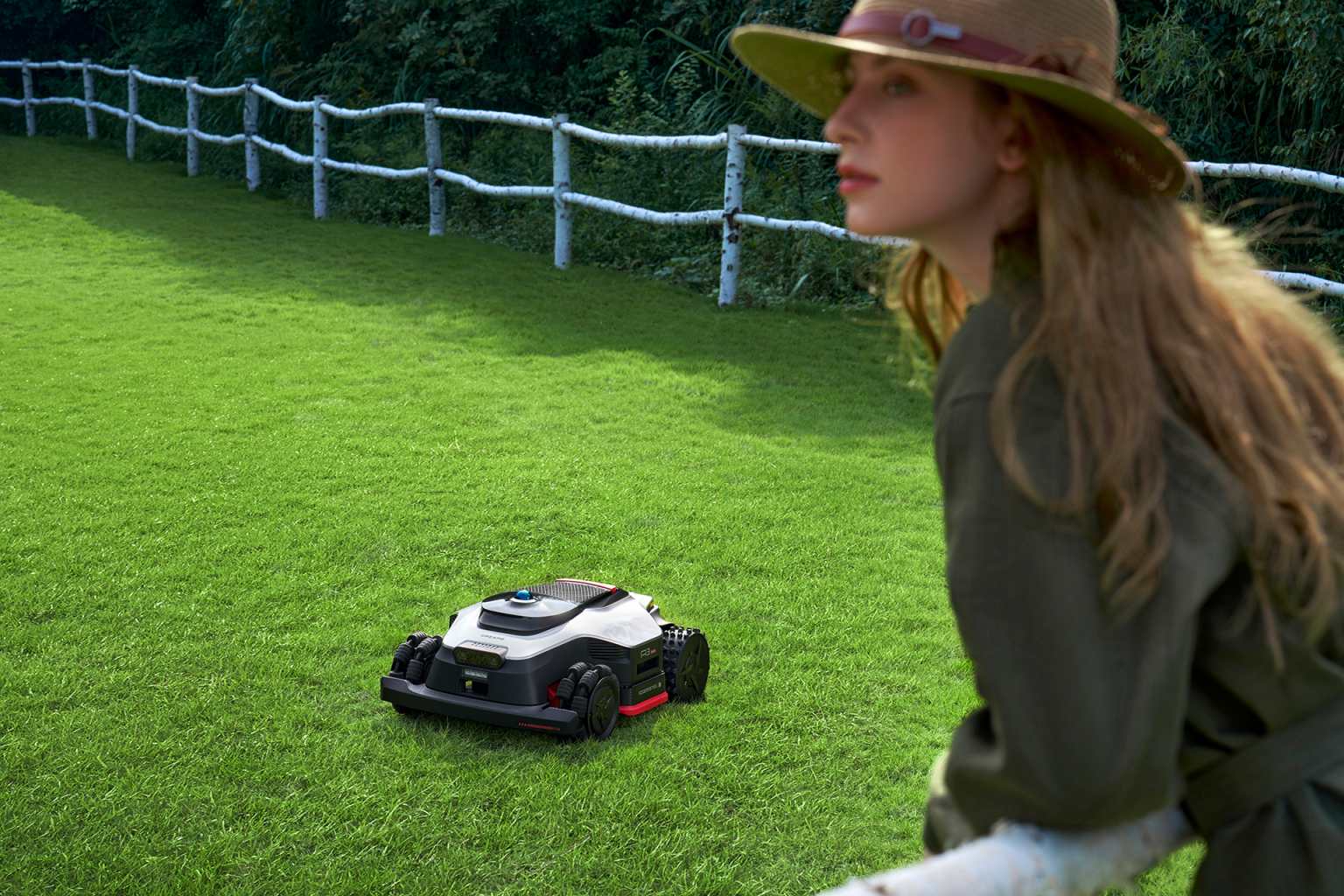 Een robotmaaier van Dreame. In de hoek staat een vrouw.